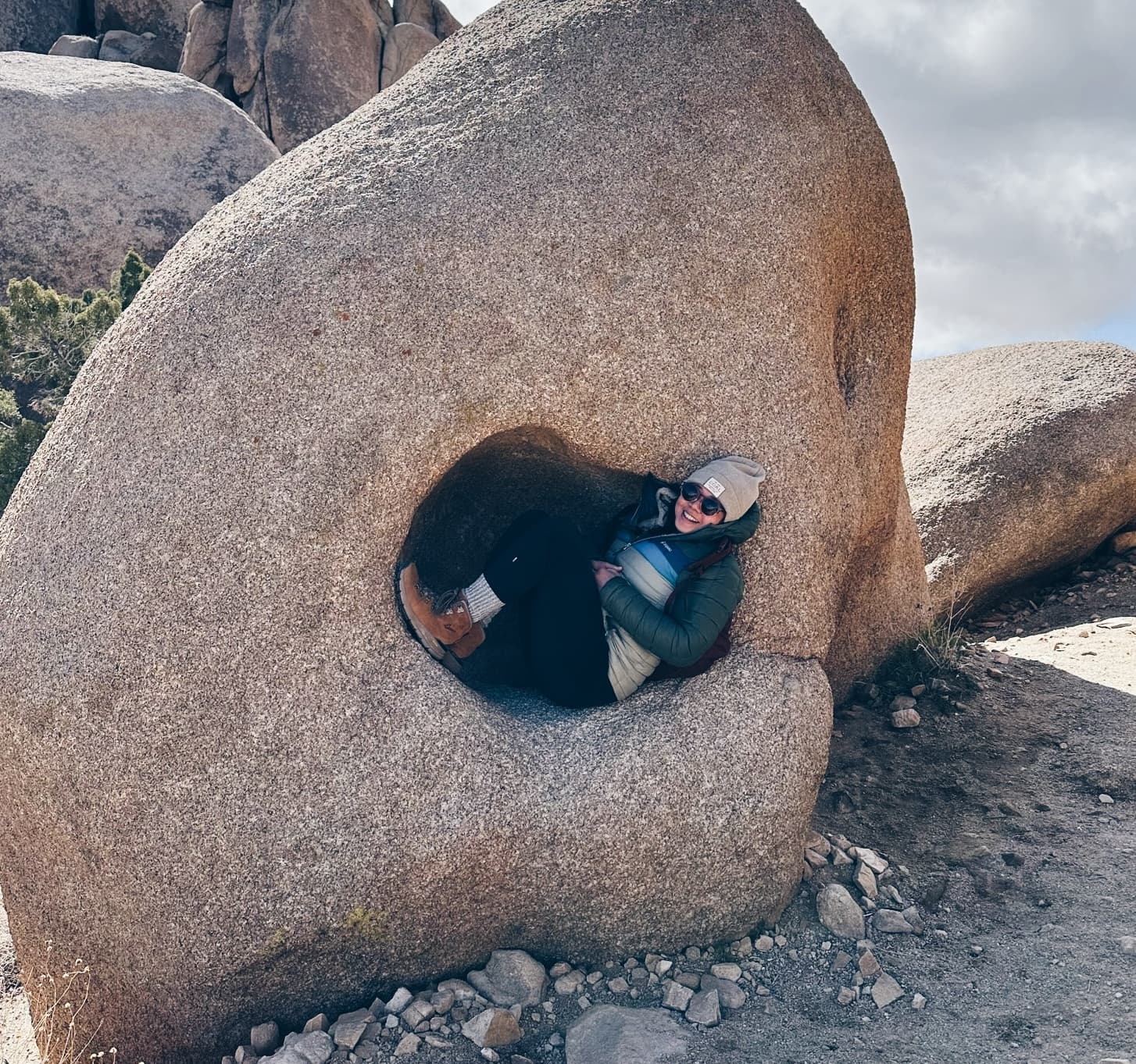 Zoei tucked inside a boulder in the desert